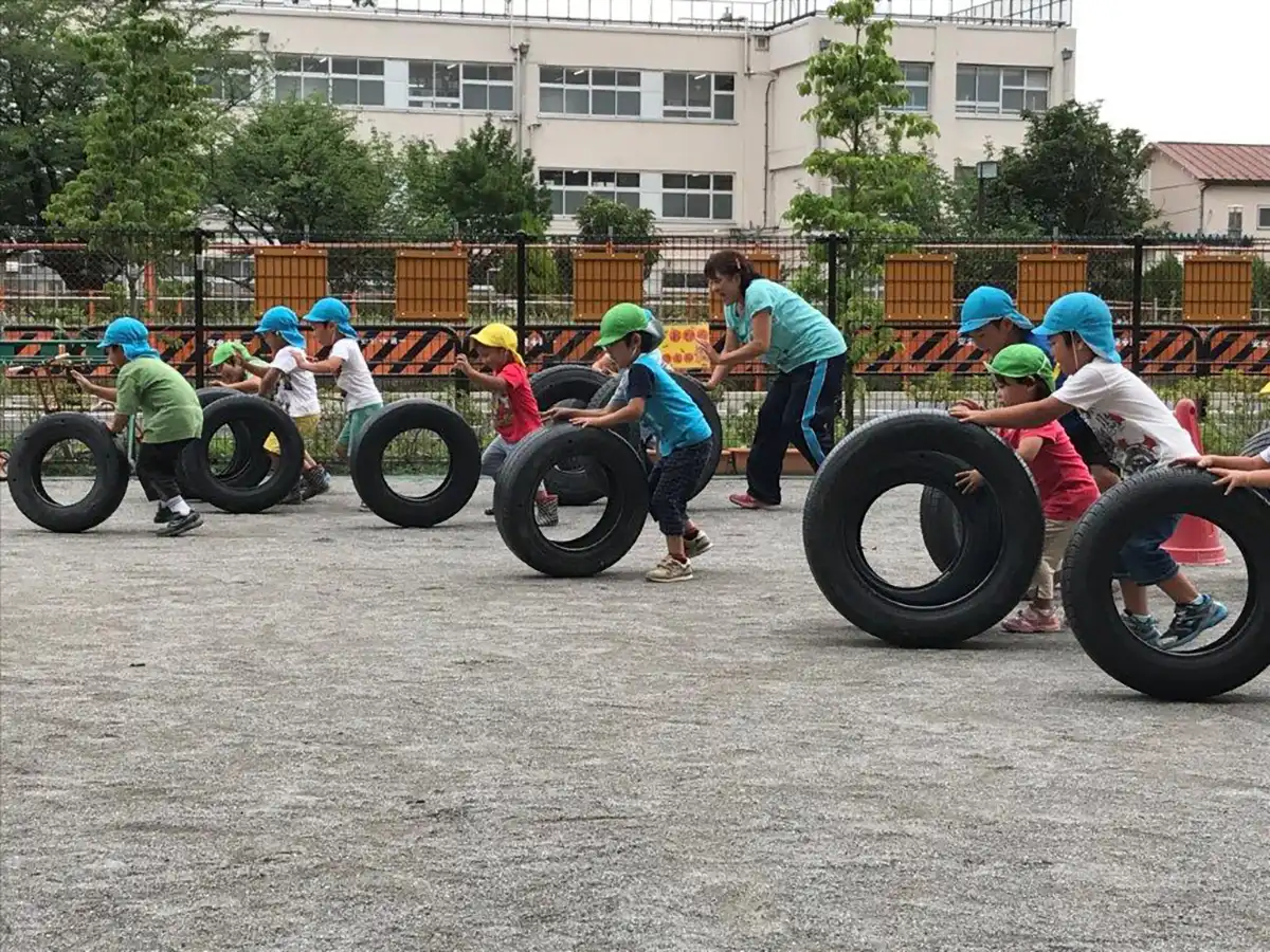 タイヤを転がして遊ぶ子供たち